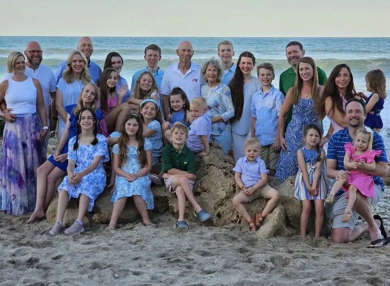 Elder Chris Fear and his wife Carol with their children and grandchildren on the beach